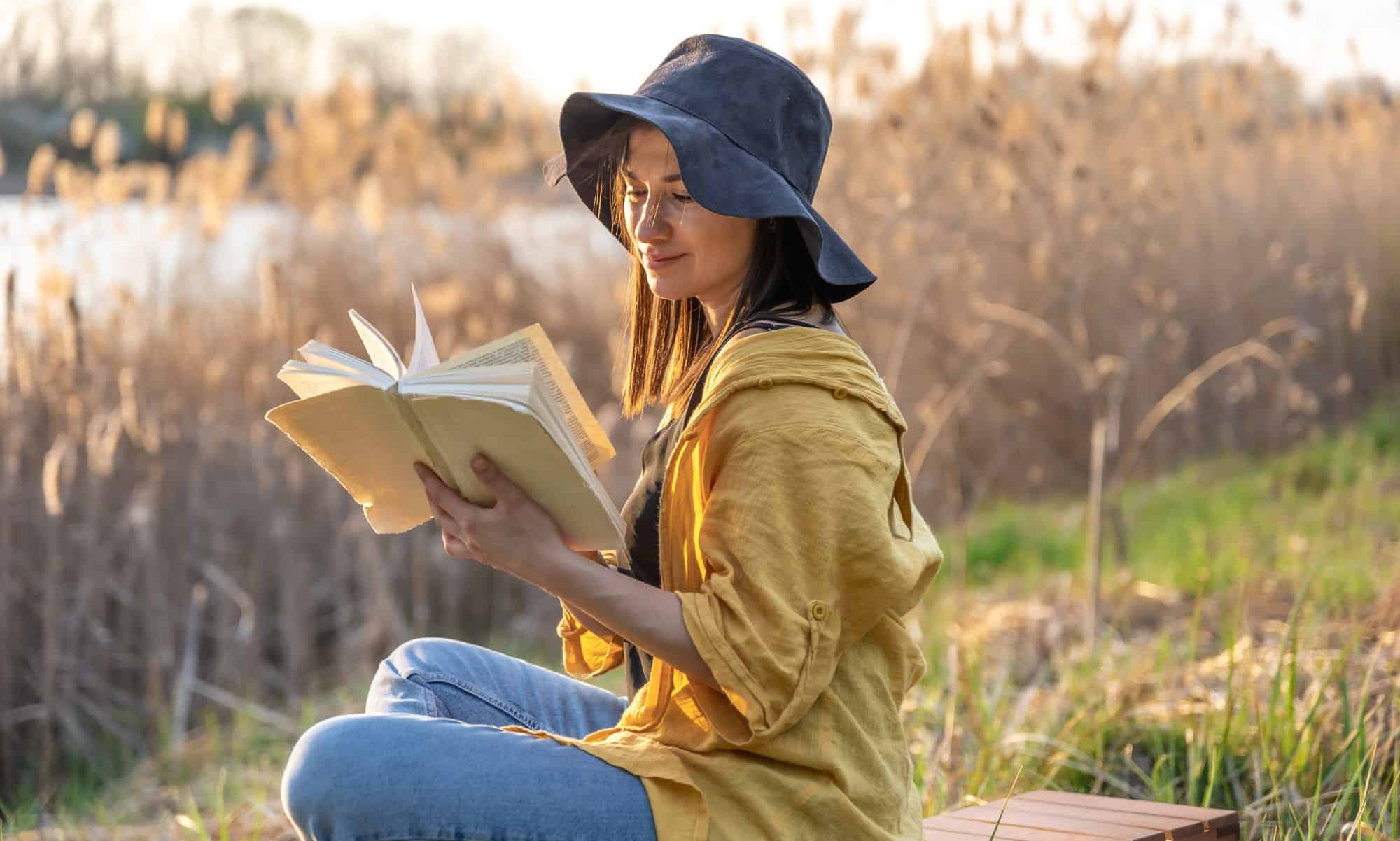 stylish-girl-with-a-book-in-her-hands-reads-at-sunset-.jpg
